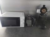 a white microwave sitting on a counter next to a coffee maker
