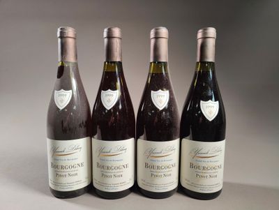 quatre bouteilles de vin sont alignées sur une table