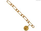 Gros plan sur un bracelet en chaîne en or sur lequel se trouve une pièce de monnaie