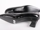 pair of black high heeled shoes on a white surface