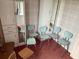 five chairs in a room with a mirror on the wall