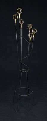 a black and gold coat rack with five coats on it