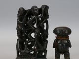 deux figurines assises l'une à côté de l'autre sur une surface blanche