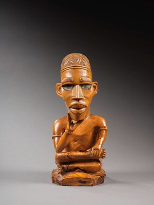 une statue en bois d'un homme avec un chapeau sur la tête
