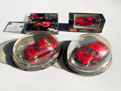 deux petites voitures rouges dans un bol en verre posé sur une table