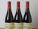 three bottles of wine sitting on top of a wooden table