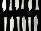 several pieces of silverware are arranged in a row on a black background