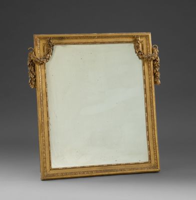 un miroir à cadre doré orné d'un motif décoratif sur le pourtour
