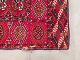 a close up of a red rug on a white surface