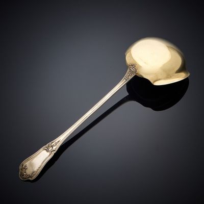 an antique silver spoon with a spoon handle on a black surface