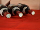 several bottles of wine are lined up on a red table