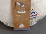 a white pillow with a tag on it sitting on a table