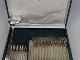 un coffret vert contenant de l'argenterie sur une table
