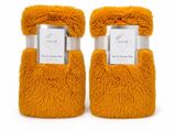 a pair of orange fuzzy slippers with a label on them