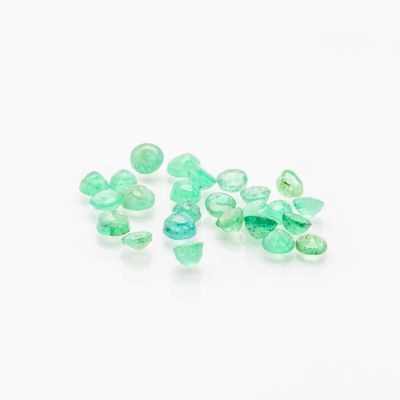 a close up of a bunch of green glass beads on a white surface