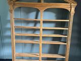 une vieille bibliothèque en bois avec un plateau en verre et des étagères