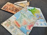 de nombreuses cartes posées par terre, avec un rouleau de papier posé dessus