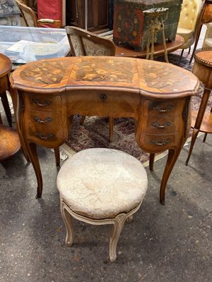une table avec un tabouret et une chaise devant