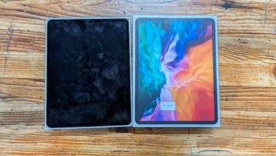 a close up of two ipads sitting side by side on a wooden surface