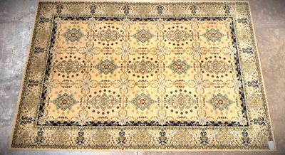 a beige rug with a blue border on a grey floor