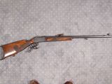 un pistolet et un fusil posés sur un lit