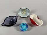 four different colored glass bowls sitting next to each other on a table