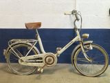 un vélo blanc garé contre un mur bleu et blanc