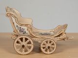 a gold carriage that is sitting on a wooden table