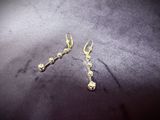 a pair of gold earrings on a black surface