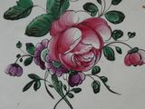 une photo d'une assiette ornée d'un motif de rose