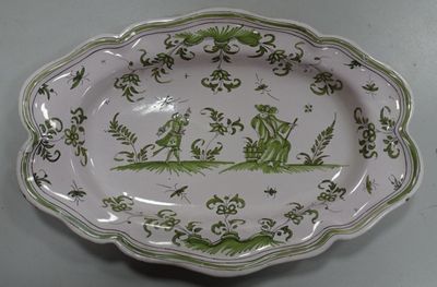 a green and white plate with a picture of a boat on it