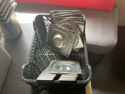 un panier rempli de casseroles et de poêles posé sur une table