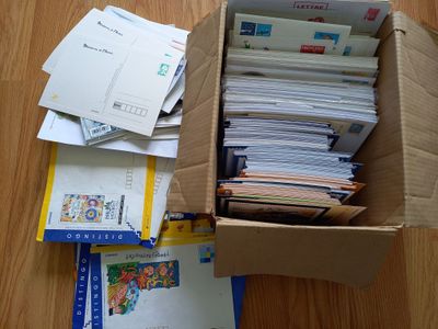une boîte remplie de courrier posée sur un plancher en bois