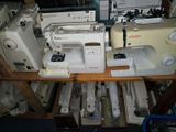 several sewing machines are lined up on a shelf in a room