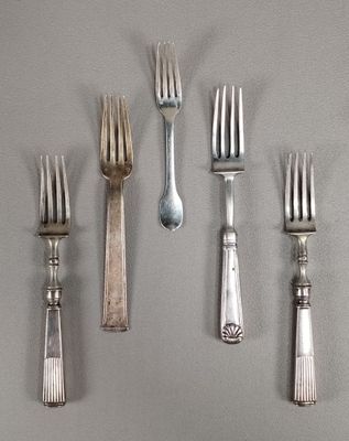 Plusieurs fourchettes et cuillères sont disposées en rangée sur une surface grise