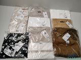 several men ' s shirts are wrapped in plastic bags on a table