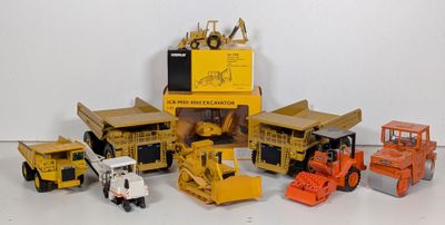 beaucoup de petits engins de chantier en jouets posés sur la table
