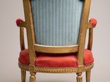 an image of a blue and gold chair with a red upholstered seat