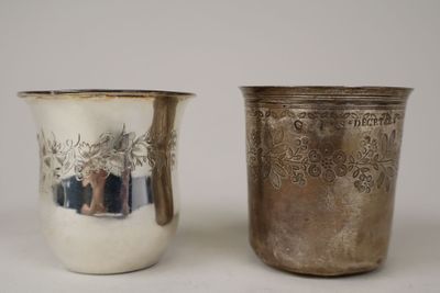 two silver cups sitting next to each other on a table