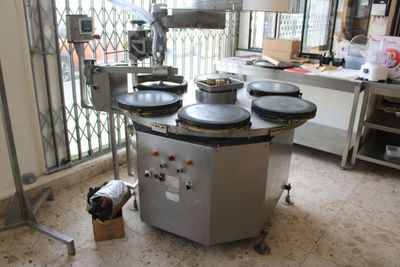 a machine that is sitting in a kitchen with a lot of pots on it