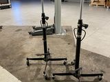 deux supports noirs équipés de roulettes, dans un entrepôt