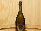 une bouteille de vin posée sur un tonneau en bois