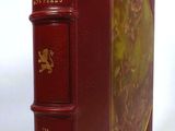 the book is red with gold trimmings on the front and sides of it
