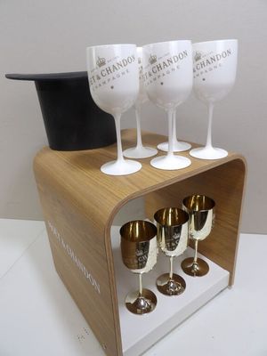quatre verres à vin et un chapeau haut-de-forme posés sur un socle en bois