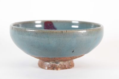a blue bowl with a red handle sitting on a table