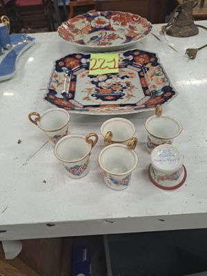 Plusieurs tasses et soucoupes sont posées sur une table dans une pièce.