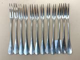 six fourchettes sont alignées en rang sur une table
