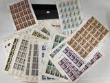 beaucoup de timbres posés sur une table, à côté d'un ordinateur portable