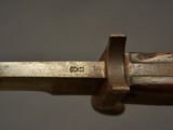 an old knife with a wooden handle on a gray surface