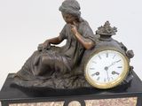a statue of a woman sitting on a table with a clock
